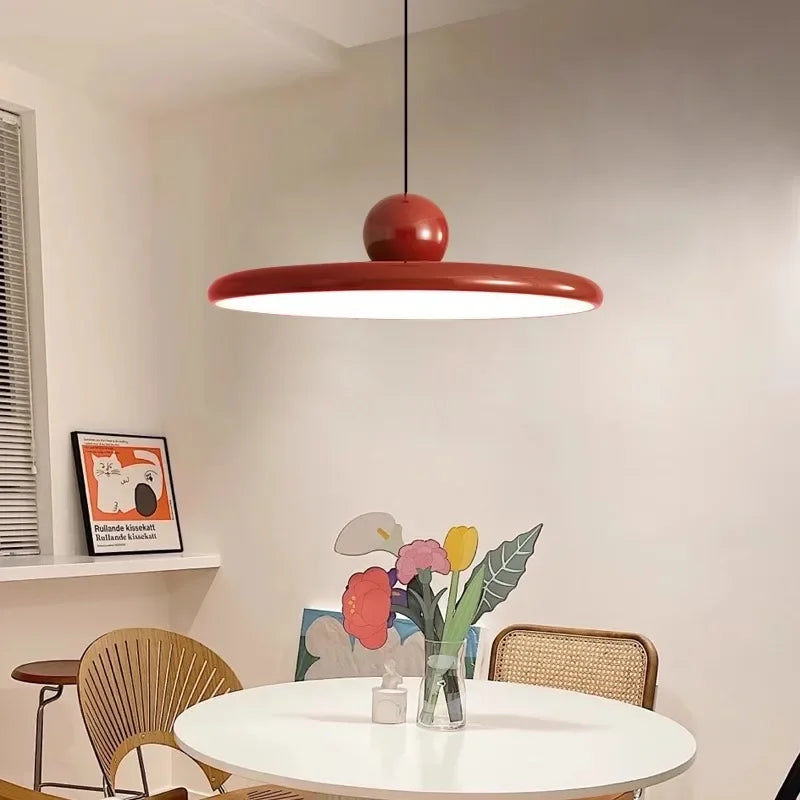 Ellis Bauhaus LED pendant with red shade over a round dining table