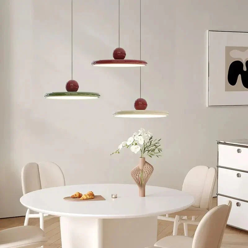 Three Ellis Bauhaus pendants in red, green and white over a dining table