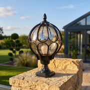 Harrow Globe Pillar Light on a stone gate pillar in a modern luxury garden on a sunny afternoon