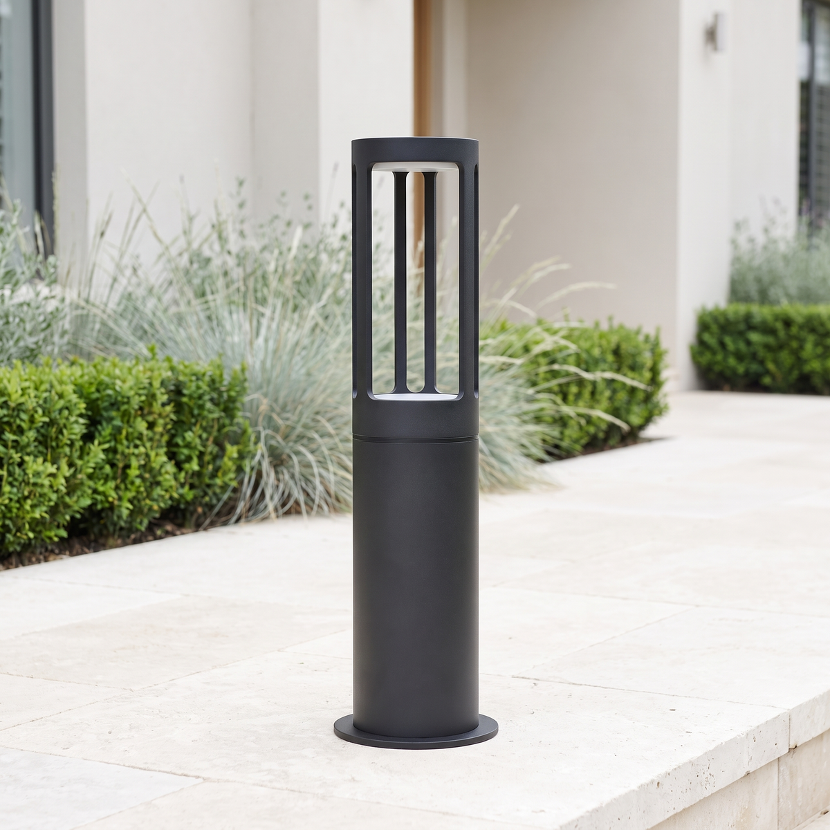 Stanton round LED bollard path light on limestone paving in a modern luxury garden